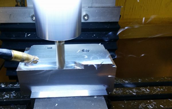Because of the three-dimensional shape of this piece, it started as a big chunk of metal. I think this is the smallest fraction of final/initial metal in any piece I've made. Check out those chips flying in the picture, by the way. This 1/4" 3-flute endmill, at 2000mm/min, eats through material at a surprising rate for a "Mini Mill". 