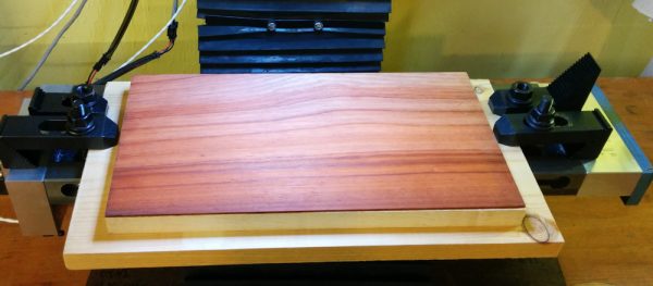 The starting point was a 12x6 piece of hard maple with a 1/16" sheet of Padauk, an exotic hardwood with very red color, on top. The plan was to route out the red part and end up with white letters on the red background. 