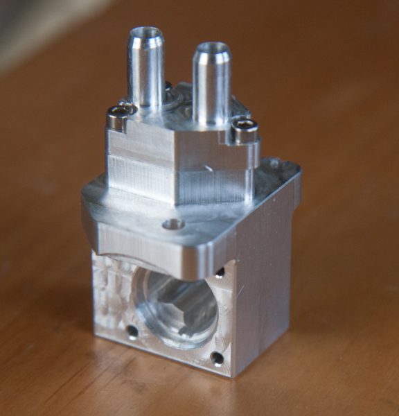 The body of the idle air control valve. The outlets are on the top and the large hole is where the stepper motor mounts.